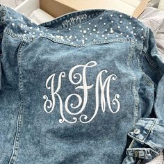 "Gorgeous monogram embroidered for you! Soft, lightweight denim jacket with pearl trim professionally embroidered. Option to add a date or word to the collar. Soft, lightweight cotton denim with aged wash for a vintage look. Feels like your favorite well-worn denim. Coordinating little-girl/flower girls sized denim jacket: https://www.etsy.com/listing/1198720656/flower-girl-embroidered-jean-jacket-with CHOOSING YOUR SIZE: For best fit, use GARMENT measurements.  Compare measurements in the size Fitted Denim Jacket With Custom Embroidery, Monogram Accessories, Jean Refashion, Bride Jean Jacket, Lightweight Denim Jacket, Embroidered Jean Jacket, Pearl Bride, Strong Shoulders, Girl Flower