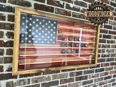 an american flag is framed in a wooden frame on a brick wall with the words woodwork above it