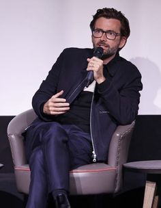 a man sitting in a chair holding a microphone