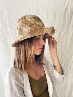 This bucket hat is casually chic and made for the beach. Beautifully crocheted in a neutral, checkerboard pattern. ﻿One size fits all. Includes adjustable strap. Brim can be folded up as pictured. Summer Plaid Bucket Hat, Casual Gingham Hats For Summer, Summer Gingham Hat With Curved Brim, Plaid Curved Brim Hat For Beach, Plaid Curved Brim Hat For The Beach, Plaid Summer Beach Hat, Plaid Hats For Summer Beach, Summer Plaid Brimmed Hat, Plaid Bucket Hat For The Beach