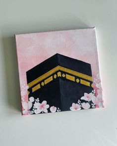 a painting of a black and gold building with white flowers on it's side