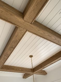 a ceiling with wooden beams and a chandelier hanging from it's side