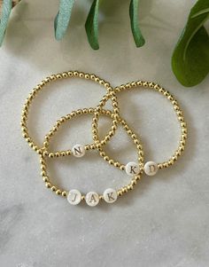 - 18k gold filled beaded initial bracelet with pearl initial beads. Perfect stacking bracelet to layer with other pieces. Great gift for mom to have children's initials, your boyfriends initials or just your own. Beaded on high quality stretch cord and secured. - 4mm 18k gold filled beads - Freshwater pearl letter beads - Choose up to 3 initials per bracelet, listing them in order in personalization box. If looking for more then 3 initials please send me a message. -Each purchase is sent in a dr Dainty Gold Charm Bracelet With Letter Beads, Yellow Gold Beaded Bracelets With Letter Beads For Gift, Personalized Round Beads Pearl Bracelet For Everyday, Dainty Gold Beaded Bracelet With Letter Beads, Dainty Gold Beaded Bracelets As Personalized Gift, 14k Gold-filled Bracelets With Letter Beads, Personalized Yellow Gold Beaded Bracelets With Round Beads, Personalized Yellow Gold Beaded Bracelets, Gold Beaded Bracelets For Personalized Gift