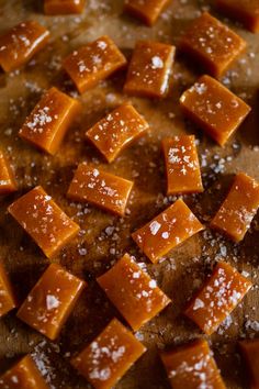 pieces of caramel on a wooden cutting board with sugar sprinkled on top