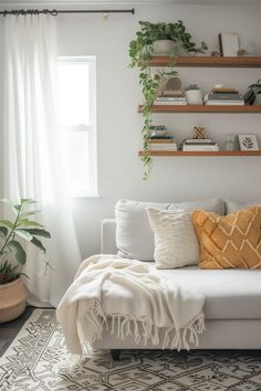 a living room with white furniture and lots of plants on the shelves over the couch