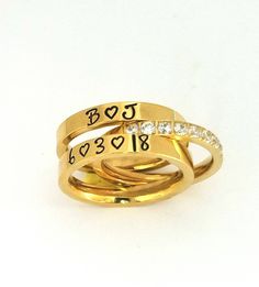 "3 pc. set of 14 kt Gold plated over stainless steel. Gorgeous Cubic zirconia has 8 channel set stones that shine brillantly. They are 2.5 mm in width and the name rings are 3 mm wide. I hand stamp each letter and then paint with the best quality jewelry paint, clean and polish. If you wish to not have paint in your stamping leave me a note with name selections.(example last pic) this same set comes in rose gold and silver stainless steel. I only stamp on the outside of the Rings. These rings ar Customizable Modern Ring Jewelry, Customizable Modern Jewelry Ring, Modern Customizable Jewelry Ring, Gold Stainless Steel Stackable Promise Rings, Modern Personalized Stackable Rings For Promise, Personalized Modern Stackable Rings For Promise, Modern Personalized Stackable Promise Rings, Personalized Modern Stackable Rings, Modern Personalized Stackable Rings