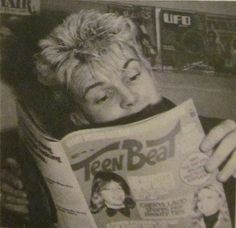 an old photo of a woman reading a newspaper