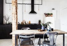 a kitchen table with four chairs and a light hanging from the ceiling in front of it