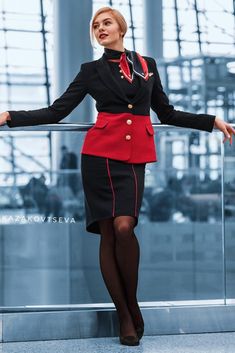 a woman in a red and black uniform posing for the camera with her arms outstretched