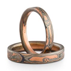 These matching Mokume Gane rings or wedding bands are shown in the Woodgrain pattern and Embers metal combination, with flat profiles and etched and oxidized finishes. The Embers palette features 14k red gold, palladium and sterling silver.Style: BandSizes: 6.25 and 9.25Palette: EmbersPattern: WoodgrainWidths: 3mm and 4mmFinish: Etched & Oxidized Profiles: Flat Price does NOT include stones or setting fees.Prices quoted are for rings up to size 9.75 unless otherwise noted. Ring sizes 10 and Round Patina Rings For Anniversary, Mokume Gane Ring, Woodgrain Pattern, Handmade Engagement Rings, Mokume Gane, Custom Wedding Rings, Wedding Band Ring, Size 10 Rings, Damascus