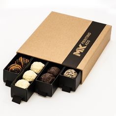 an open box with four different types of chocolates in it on a white surface