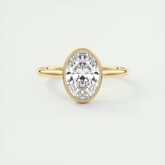 a yellow gold ring with a oval cut diamond in the center, on a white background