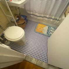 a bathroom with a blue and white tile floor next to a sink, toilet and shower