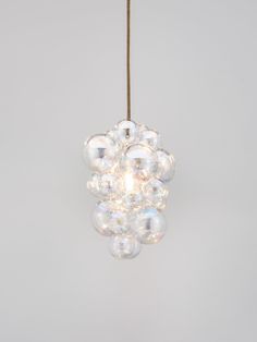 a cluster of bubbles hanging from a string on a light fixture in a white room