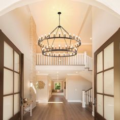 a chandelier hanging from the ceiling in a large room with wood flooring