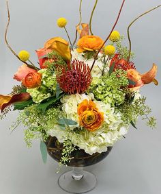 an arrangement of flowers in a glass vase