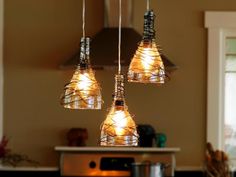 three lights are hanging from the ceiling in a kitchen with an oven and microwave behind them