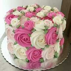 a large cake with pink and white flowers on it