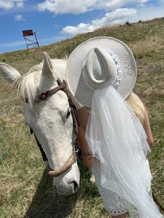 a white horse wearing a bridal gown and hat