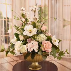 a vase filled with lots of flowers on top of a table