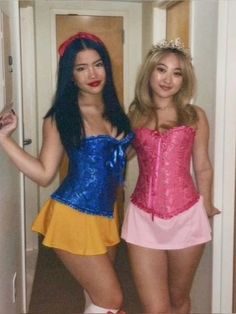 two women dressed in costumes standing next to each other