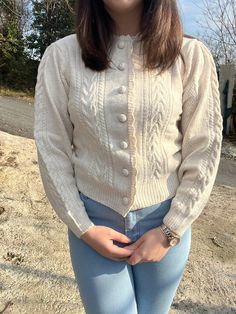 a woman standing in front of a tree with her hands on her hips and smiling