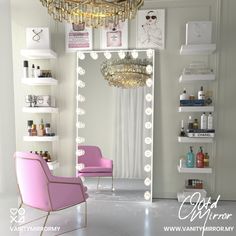 a pink chair sitting in front of a mirror with lights hanging from it's sides