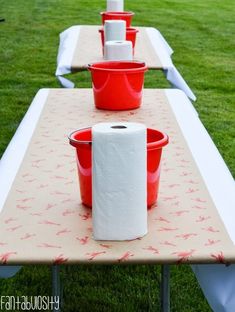 some red buckets are sitting on top of a table