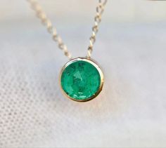 Genuine earth mined emerald tourmaline set in 14k gold. Stone Size : 4mm Necklace Length : see options Metal : 14k Gold Gemstone : Earth Mined Emerald Packaging : All products purchased from us come in a gift box. If you need to include a message, kindly leave us a note when purchasing. Care Recommendations: When not in use, keep earrings enclosed in a box or pouch to minimize exposure to moisture in air. Do not spray aromatics directly onto product. Minimize exposure to water. Clean with a soft Everyday Yellow Gold Emerald Necklace For May Birthstone, Minimalist Round Emerald Necklace For May Birthstone, Minimalist Emerald Necklace In Yellow Gold, Round Emerald Necklace With Bezel Setting For May Birthstone, Dainty Round Emerald Necklace, Dainty 14k Gold Round Emerald Necklace, 14k Gold Round Emerald Birthstone Necklace, Round Bezel Set Emerald Necklace For May Birthstone, 14k Gold Round Emerald Necklace With Bezel Setting