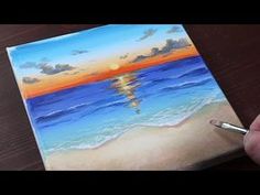 someone is painting a sunset at the beach with watercolors on canvase paper