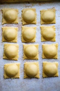 eight ravioli shells on a baking sheet ready to go into the oven