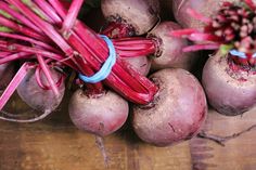 some red beets are on a wooden table