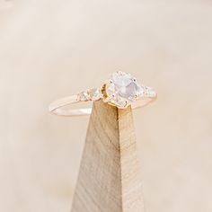 a diamond ring sitting on top of a wooden stand