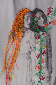 two women with long hair and flowers on their heads are standing next to each other