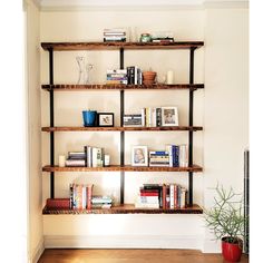 a living room filled with lots of books on wooden shelves