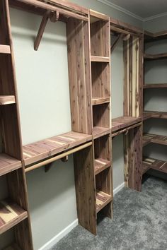 an empty room with wooden shelves and shelving units on the wall, in front of a carpeted floor