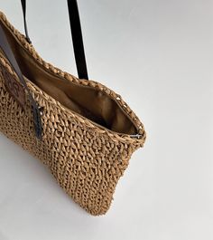 Embark on a journey of coastal elegance with our stunning Aria woven raffia tote, embodying the essence of Mediterranean living. Meticulously handcrafted with detailed raffia weaving and featuring sturdy brown handles, this tote exudes an aura of refined sophistication. Embrace the enchanting spirit of the Mediterranean with this indispensable accessory, a harmonious fusion of craftsmanship and style destined to captivate admirers. Details: Height: 14" Width: 18" Authentic raffia Handmade produc Beige Straw Bag With Woven Leather Top Handle, Woven Leather Double Handle Beach Bag, Double Handle Woven Leather Beach Bag, Eco-friendly Straw Bucket Bag With Woven Leather, Chic Woven Leather Straw Bag With Top Handle, Woven Leather Top Handle Straw Bag For Travel, Top Handle Straw Bag With Woven Leather For Travel, Crochet Tote Bag With Woven Leather, Everyday Crochet Bag With Woven Leather And Double Handle