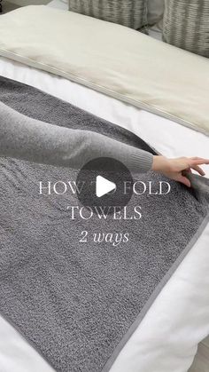 a woman laying on top of a bed next to a gray and white blanket with the words how fold towels