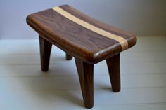 a small wooden bench sitting on top of a white floor