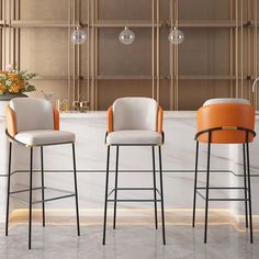 three modern bar stools in front of a marble countertop with flowers on it