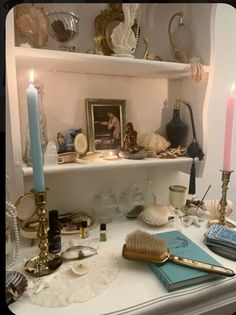 a shelf with candles, pictures and other items on it