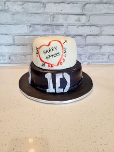 a cake with writing on it sitting on top of a table next to a brick wall