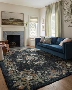 a living room filled with furniture and a fire place under a painting on the wall