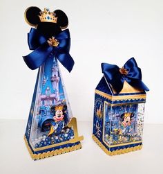 two small boxes are decorated with disney mouses and princesses, one is blue and the other is gold