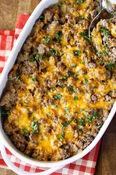 ground beef casserole with cheese and parsley in a white dish on a red checkered napkin