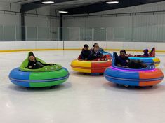 four people in bumper boats on an ice rink