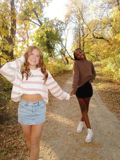 two girls walking down a path holding hands