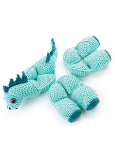 three crocheted dragon slippers sitting on top of each other in front of a white background