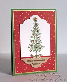 a christmas card with a small tree on the front, and merry wishes below it