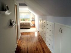 an empty bedroom with white cabinets and wood floors